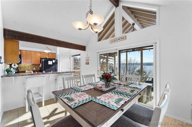 dining room featuring light tile patterned flooring, a textured ceiling, a chandelier, and beamed ceiling