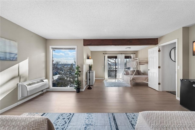 living room featuring a textured ceiling, an AC wall unit, and a wealth of natural light