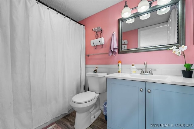 bathroom featuring a textured ceiling, hardwood / wood-style floors, vanity, and toilet