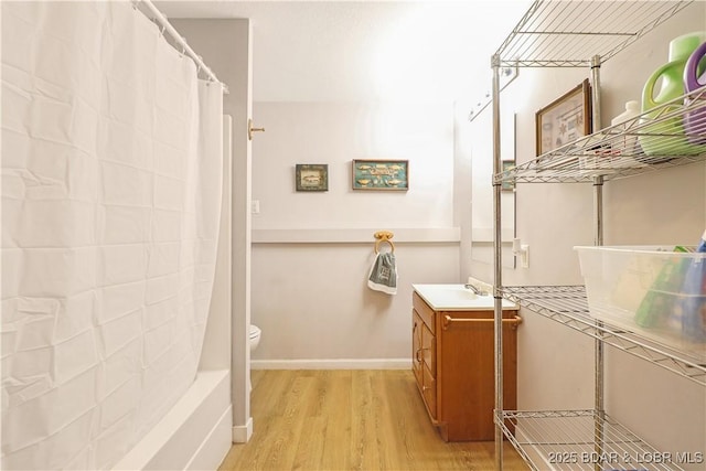 bathroom with wood-type flooring, curtained shower, vanity, and toilet