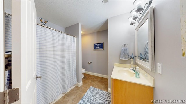 bathroom with vanity, a textured ceiling, tile patterned floors, and toilet