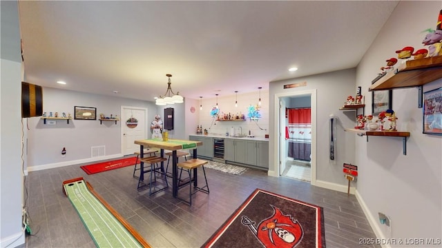 dining space with dark hardwood / wood-style floors, indoor wet bar, and beverage cooler