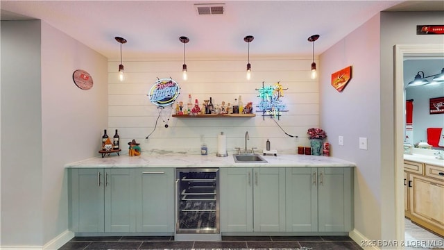 bar featuring visible vents, wine cooler, decorative light fixtures, wet bar, and a sink