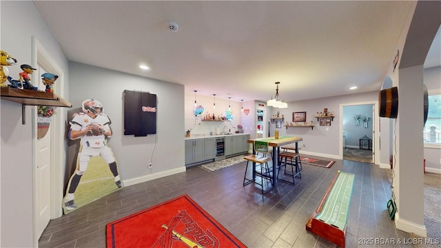 interior space featuring recessed lighting, beverage cooler, baseboards, and dark wood-style flooring