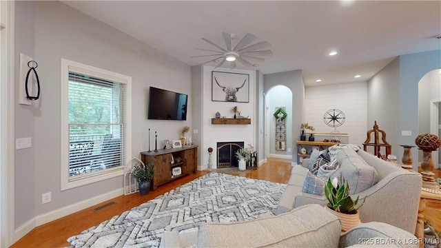 living room featuring ceiling fan and light hardwood / wood-style flooring