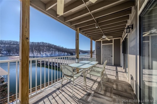 balcony featuring ceiling fan and a water view