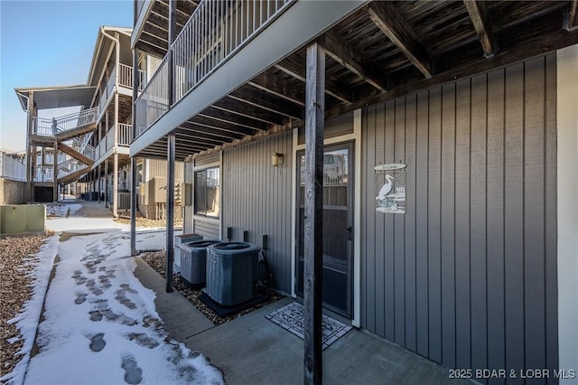 snow covered patio with central air condition unit