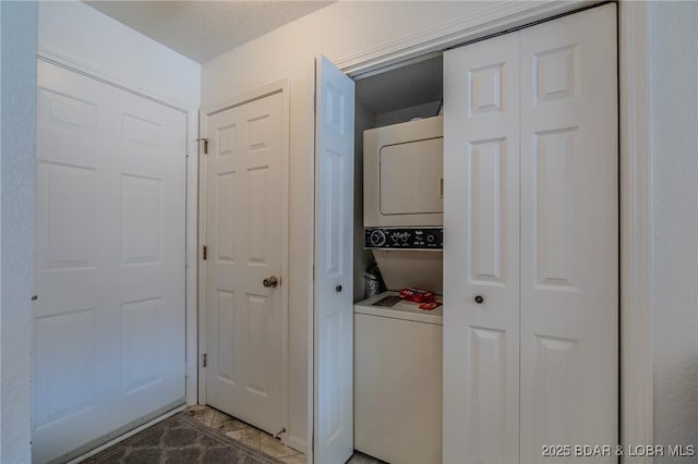 washroom featuring stacked washer / dryer