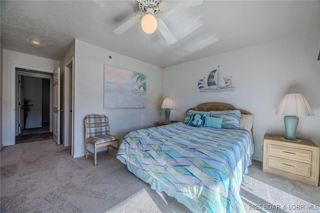 carpeted bedroom featuring ceiling fan and a textured ceiling