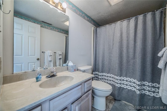 bathroom featuring a textured ceiling, toilet, and vanity