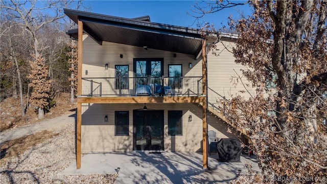 rear view of house featuring a patio area and a balcony