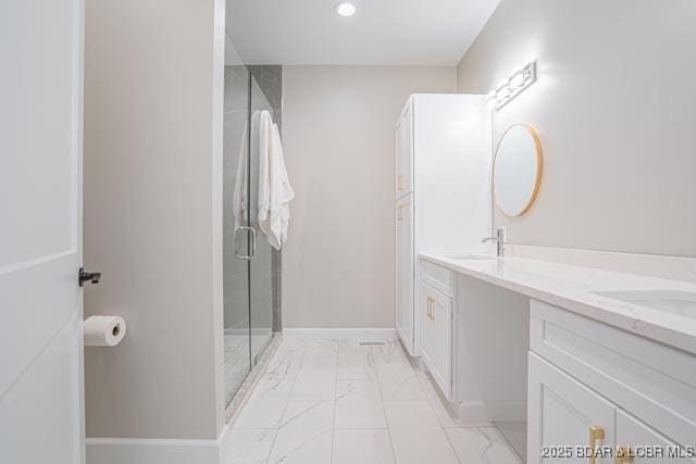 bathroom featuring a shower with shower door and vanity