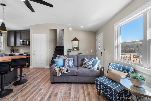 living room with hardwood / wood-style flooring, ceiling fan, lofted ceiling, and plenty of natural light