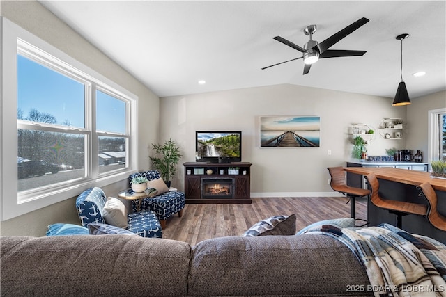 living room with ceiling fan, hardwood / wood-style floors, and vaulted ceiling