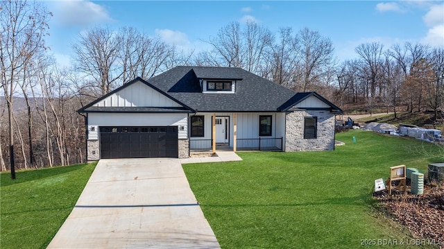 view of front of home with a front yard, covered porch, and a garage