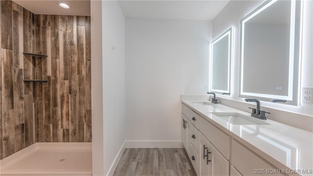 bathroom with a shower, wood-type flooring, and vanity