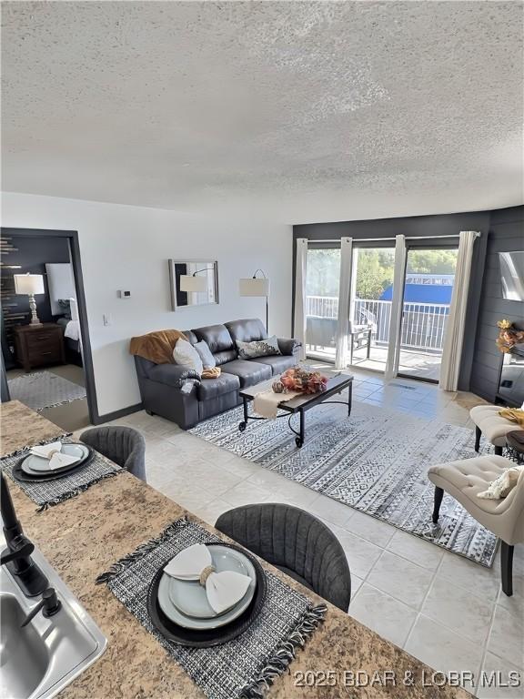 living room with a textured ceiling and light tile patterned floors