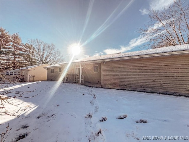 view of snow covered back of property