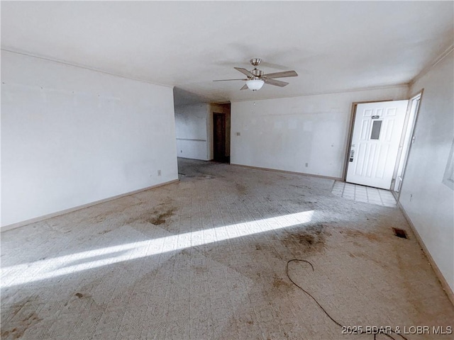 carpeted spare room featuring ceiling fan