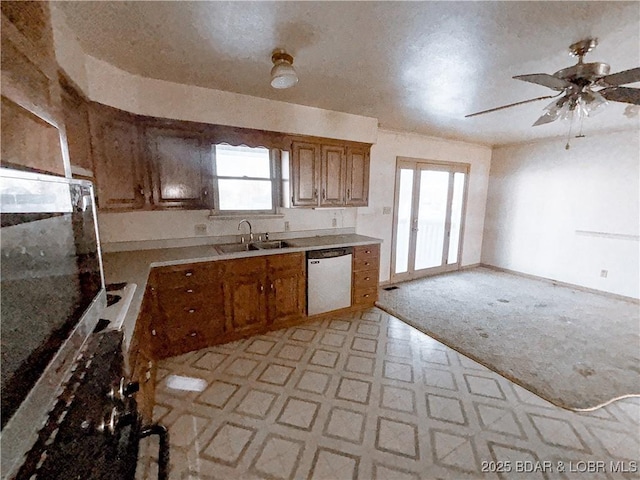 kitchen with a wealth of natural light, ceiling fan, sink, white dishwasher, and light colored carpet