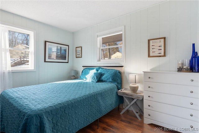 bedroom featuring dark hardwood / wood-style floors and wood walls