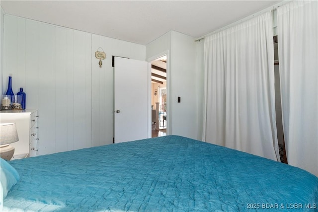 unfurnished bedroom featuring wooden walls