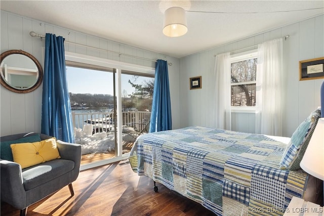 bedroom featuring hardwood / wood-style flooring, access to exterior, and a textured ceiling