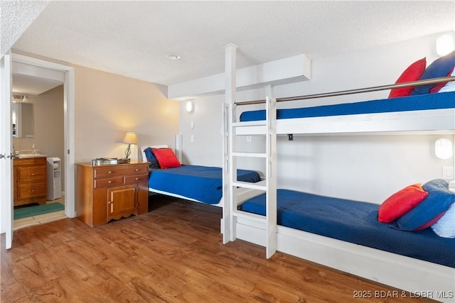 bedroom featuring a textured ceiling and hardwood / wood-style flooring