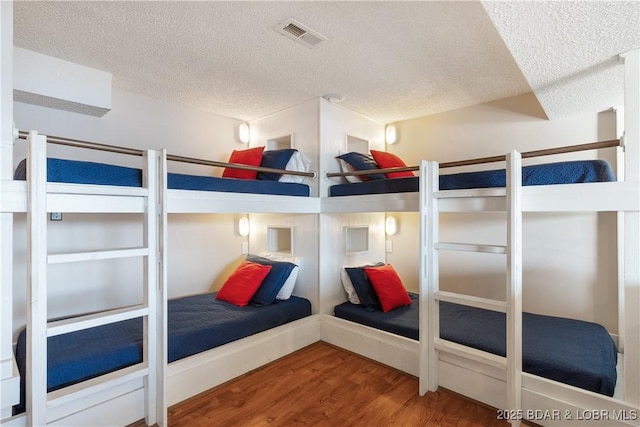 bedroom featuring wood-type flooring and a textured ceiling