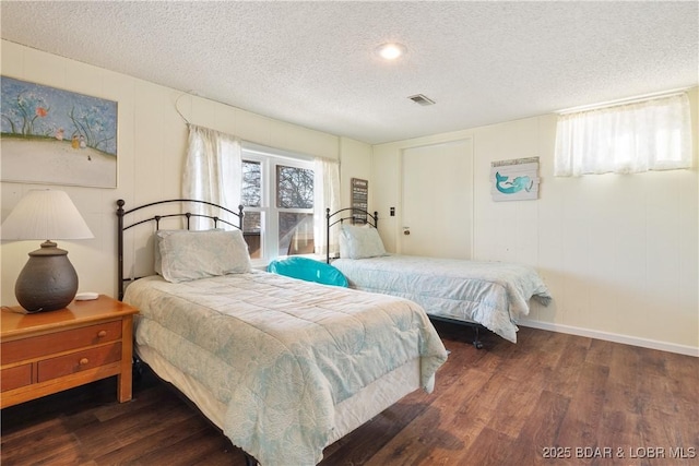 bedroom with a textured ceiling and dark hardwood / wood-style floors