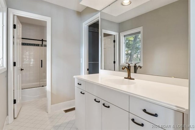 bathroom with bath / shower combo with glass door, tile patterned floors, and vanity