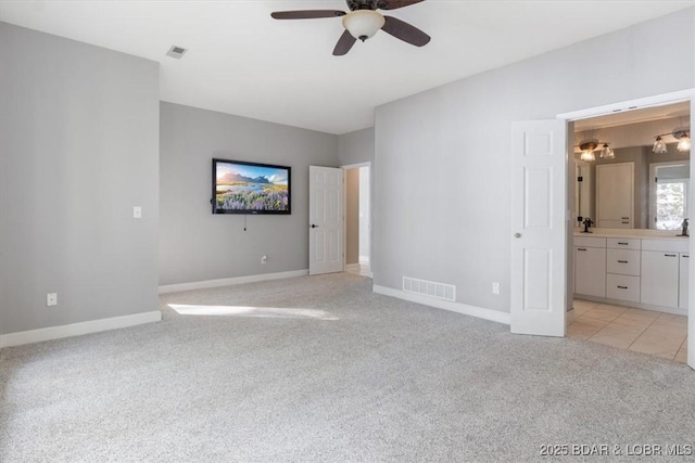 unfurnished bedroom with ceiling fan, sink, connected bathroom, and light carpet