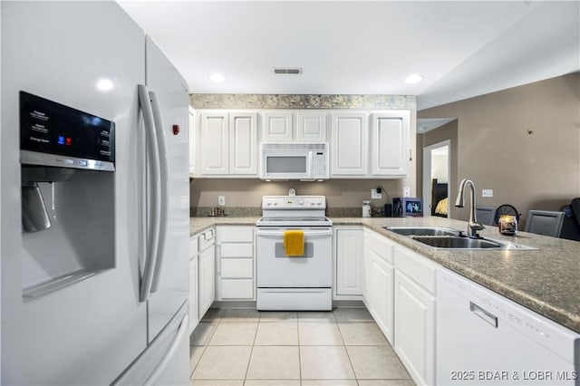 kitchen featuring light tile patterned floors, kitchen peninsula, white appliances, white cabinets, and sink