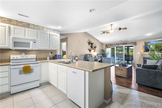 kitchen featuring white cabinets, kitchen peninsula, sink, and white appliances