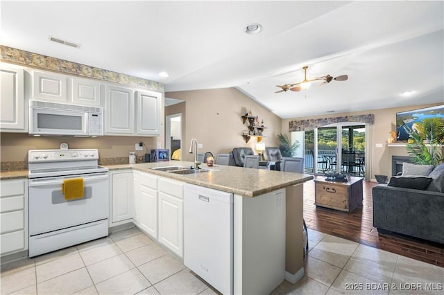 kitchen featuring visible vents, open floor plan, white appliances, and a sink