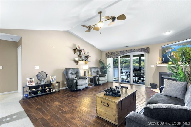 living room with vaulted ceiling, a ceiling fan, baseboards, and wood finished floors