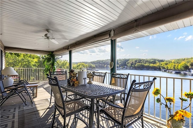 wooden terrace with a water view and ceiling fan