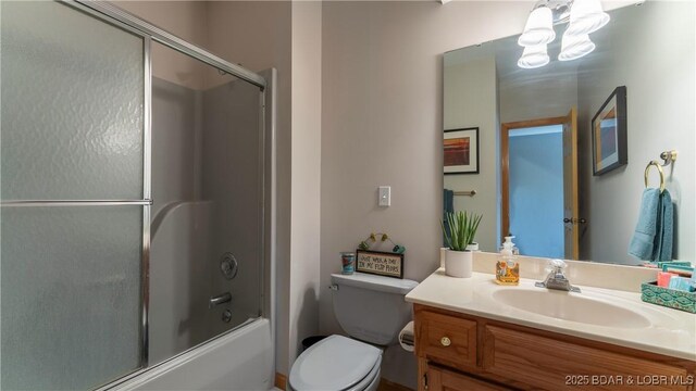 full bathroom with toilet, bath / shower combo with glass door, and vanity