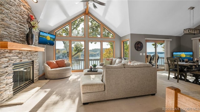 carpeted living room featuring ceiling fan, high vaulted ceiling, and a fireplace