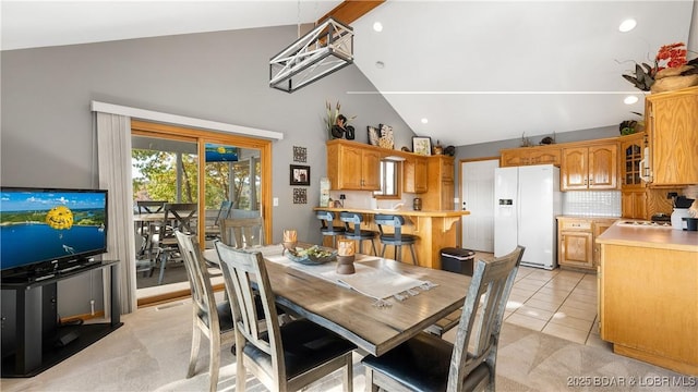 dining area with light tile patterned floors and lofted ceiling