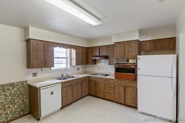 kitchen featuring decorative backsplash, sink, and white appliances