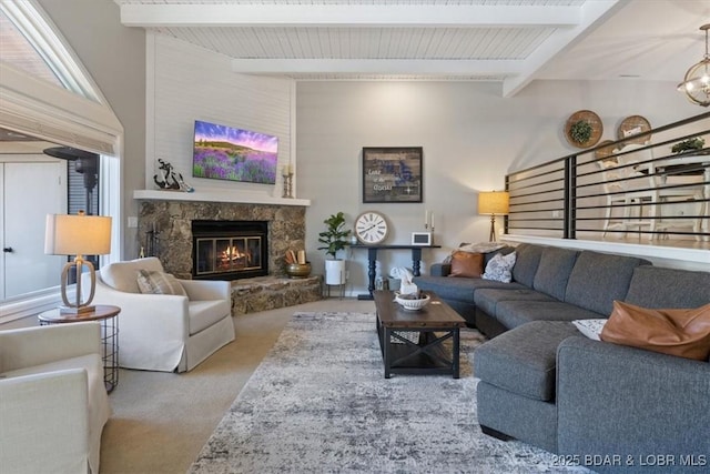 carpeted living room featuring beamed ceiling and a stone fireplace