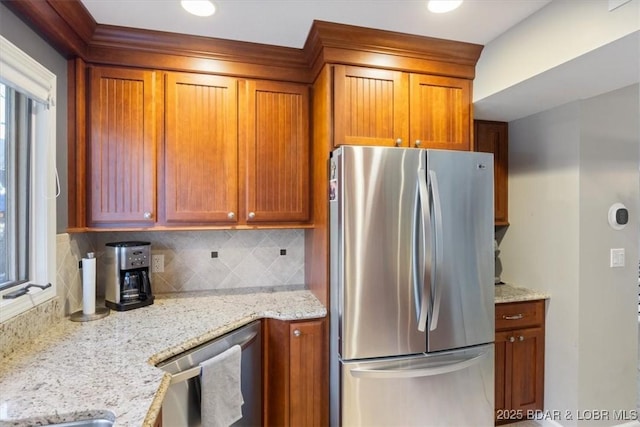 kitchen with light stone counters, stainless steel appliances, and tasteful backsplash