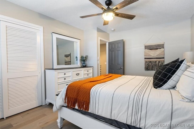 bedroom featuring ceiling fan, light hardwood / wood-style floors, and a closet