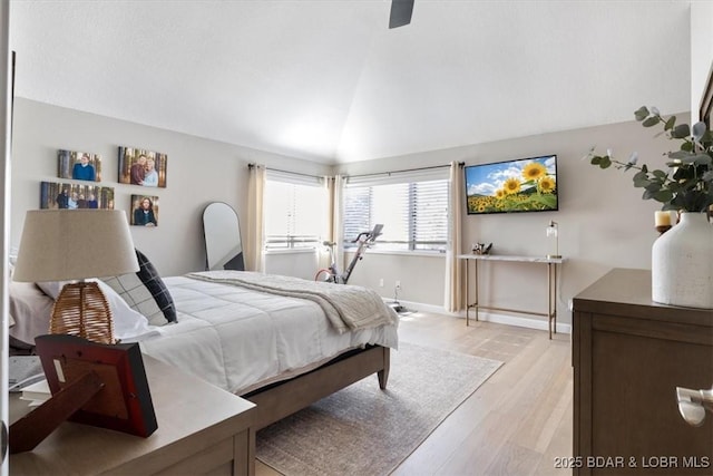 bedroom featuring ceiling fan, lofted ceiling, and light hardwood / wood-style floors