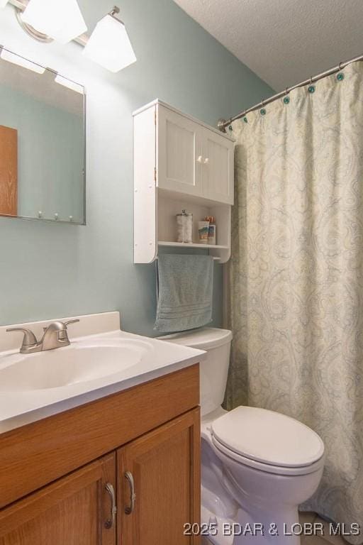 bathroom with a shower with curtain, vanity, a textured ceiling, and toilet