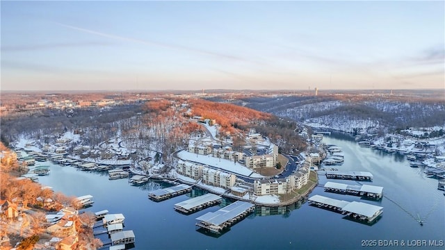 aerial view at dusk featuring a water view