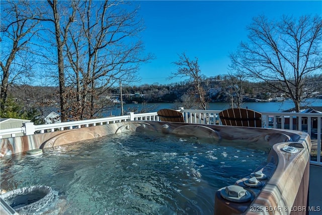 view of swimming pool with a water view and a hot tub