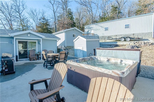 view of patio with a hot tub and a storage unit