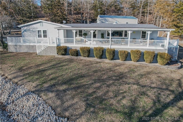 back of property with covered porch and a yard